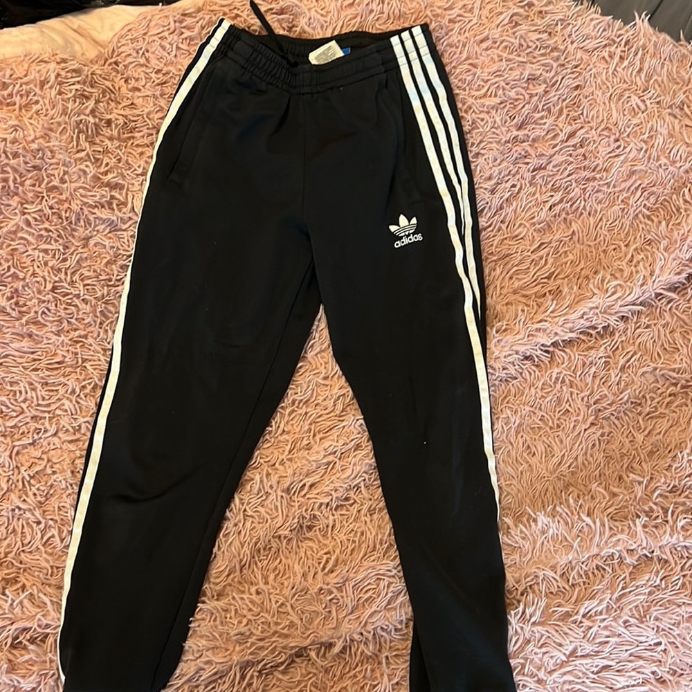 Black and white adidas joggers, worn
